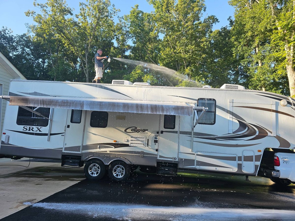 C.C. Pressure Washing crew member washing the roof of an RV camper